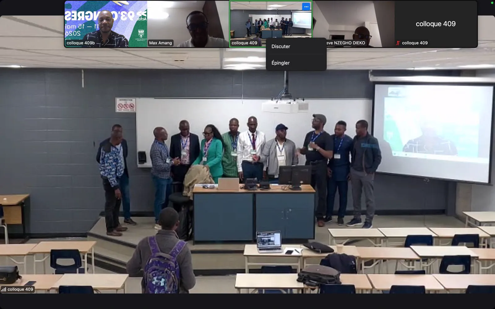 Session du colloque 409 en format hybride, avec des intervenants à distance affichés sur l’écran de la salle