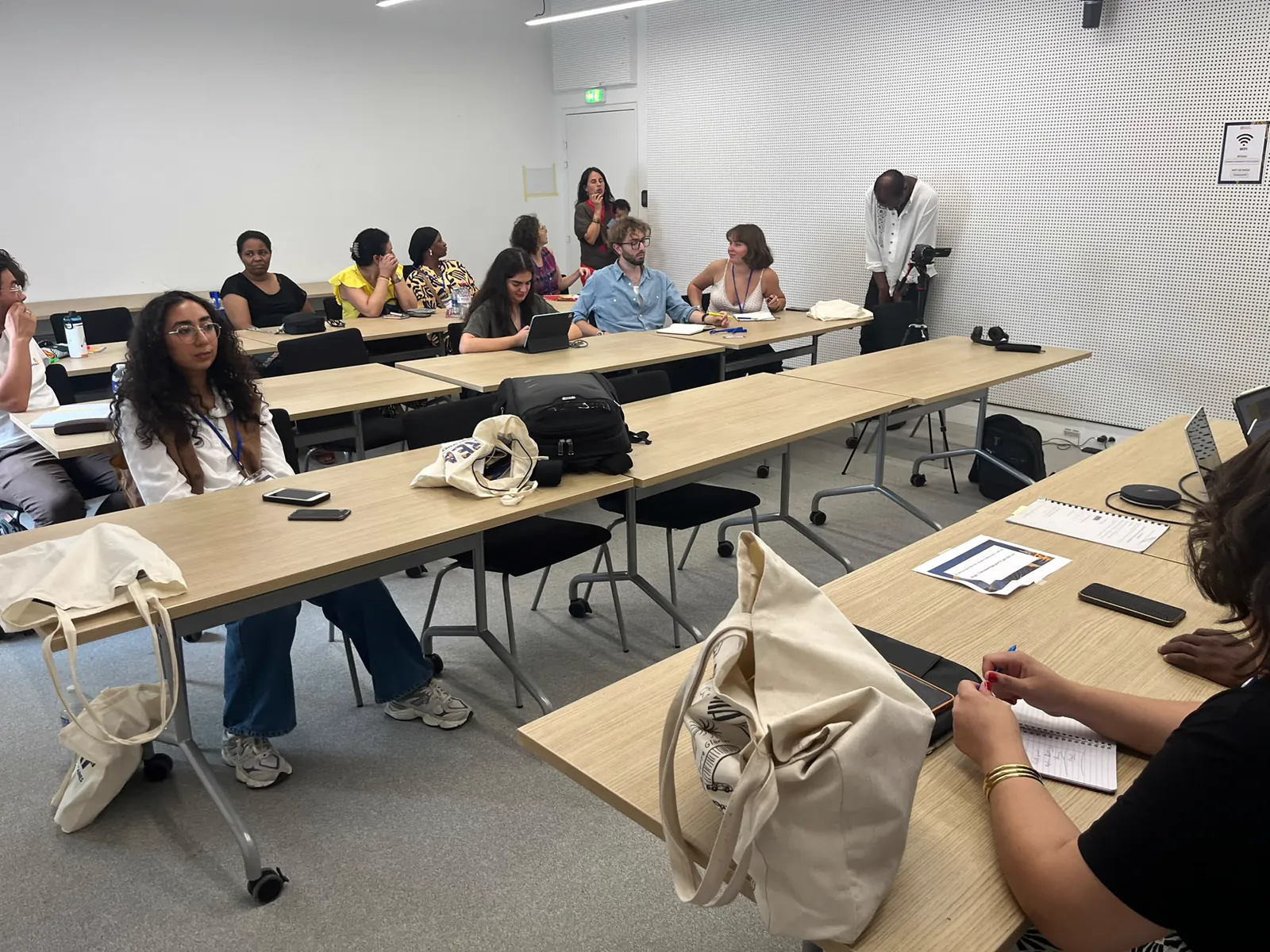 Participants réunis autour de tables dans une salle d’atelier