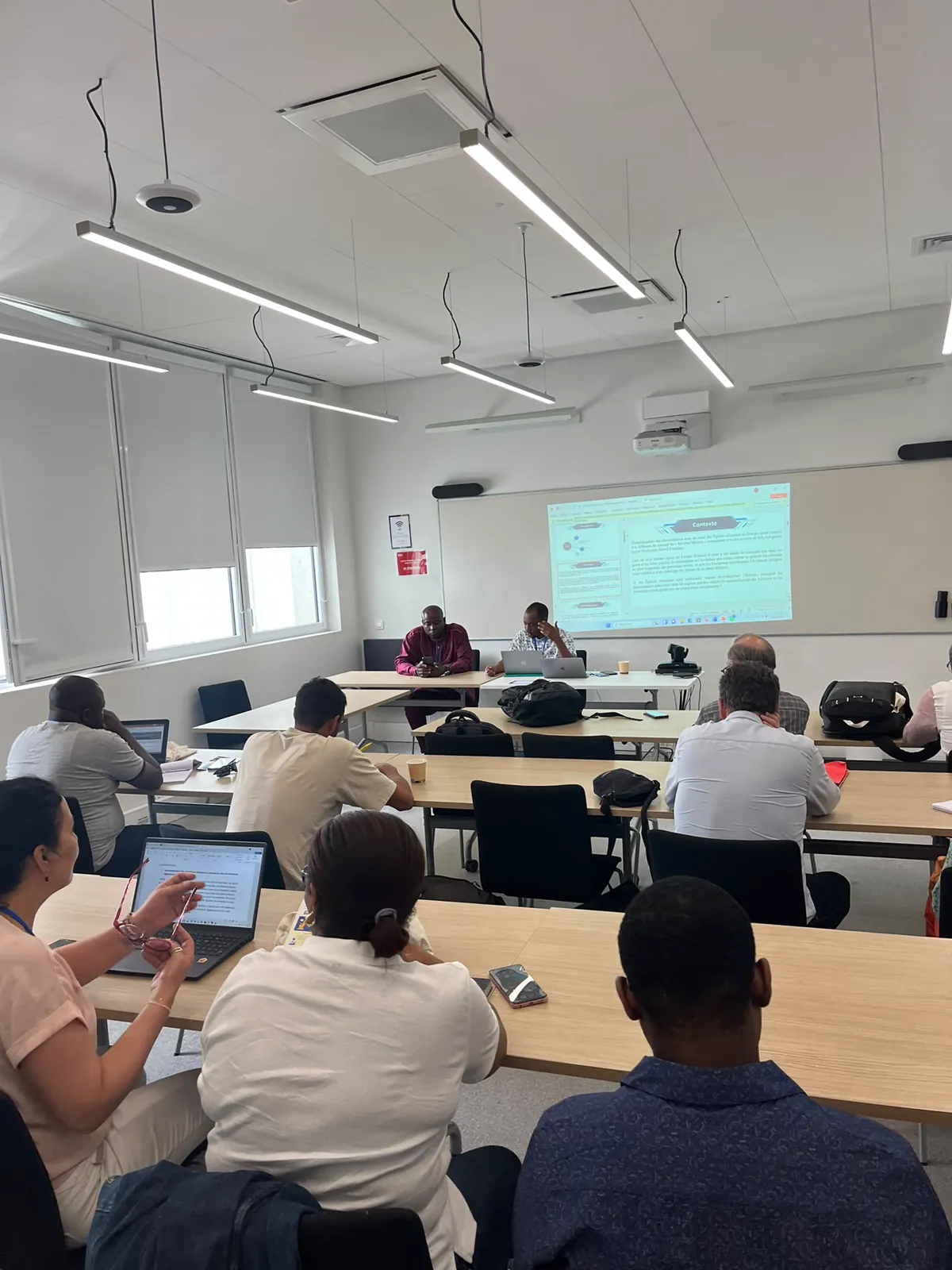 Session de travail en salle : participants écoutant un intervenant