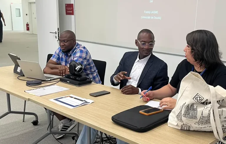 Trois chercheurs en discussion à une table de travail